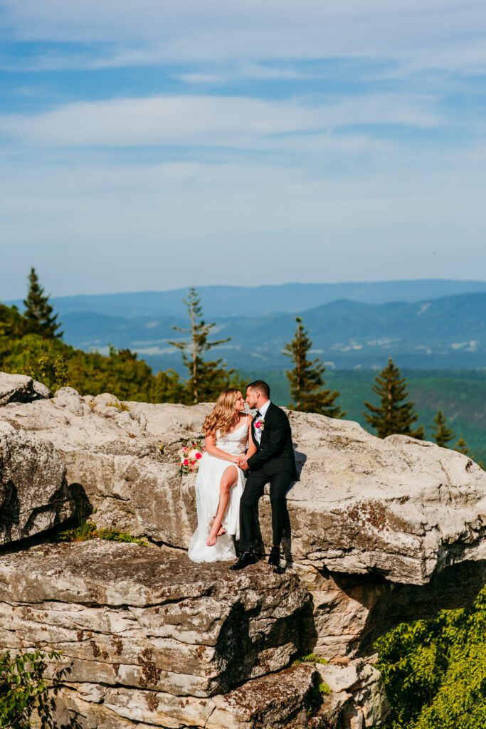 Couple sitting barefoot on a cliff edge sharing an intimate moment after their West Virginia elopement ceremony