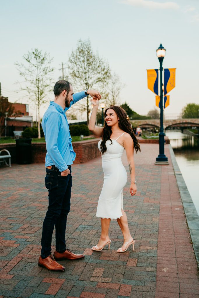Couple dancing by the water at Carroll Creek Park during downtown Frederick MD engagement session